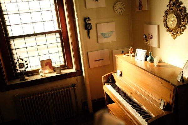 A wide view of the installation, including sentimental objects and glass bottles hanging from the ceiling.