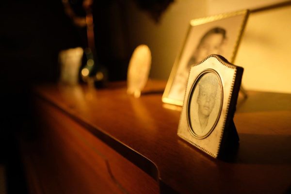 Framed photographs on top of a piano.