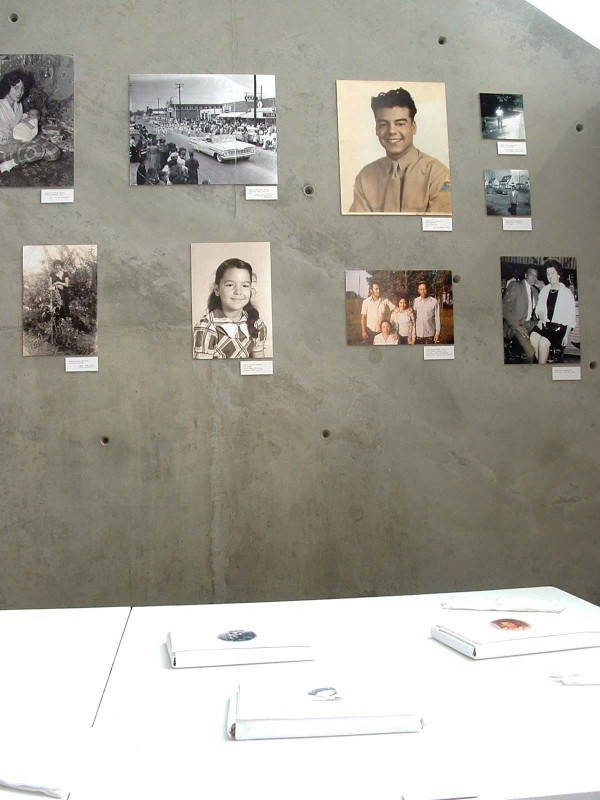 The Lumbee Legends books on a table and photos of family members featured in the project on a wall.