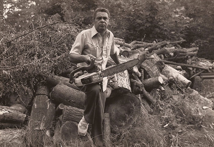 Hal Hunt Sr. cutting up wood with a chainsaw.