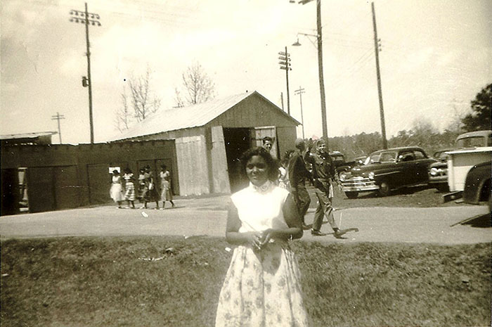 Minnie Sampson Maynor standing outside.
