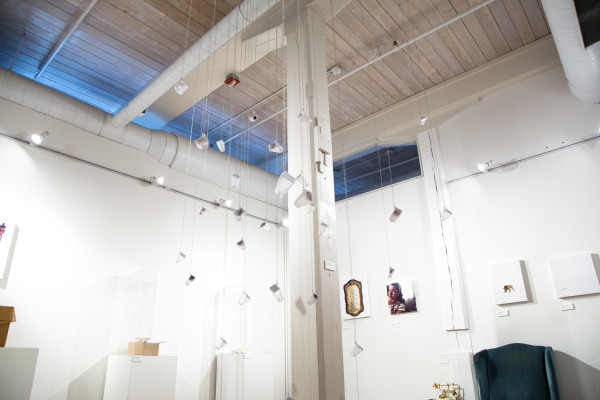 Glass bottles hanging from the ceiling on strings.
