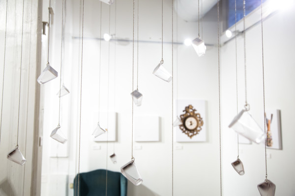 Glass bottles hanging from the ceiling on strings.