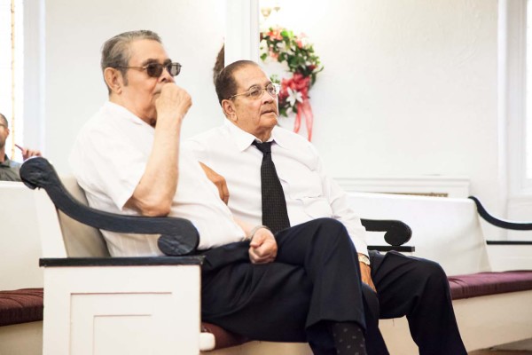 Two people seated, watching intently.