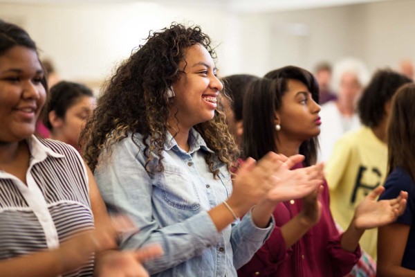 Audience members clapping and smiling.