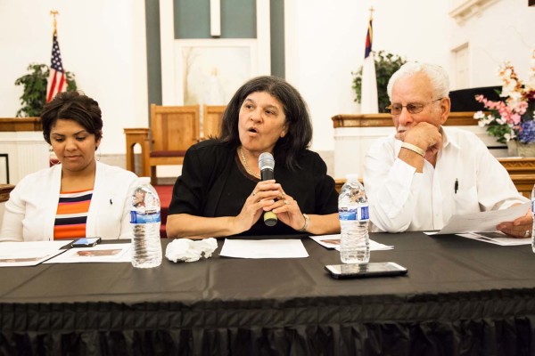 A performer speaking, holding a microphone.