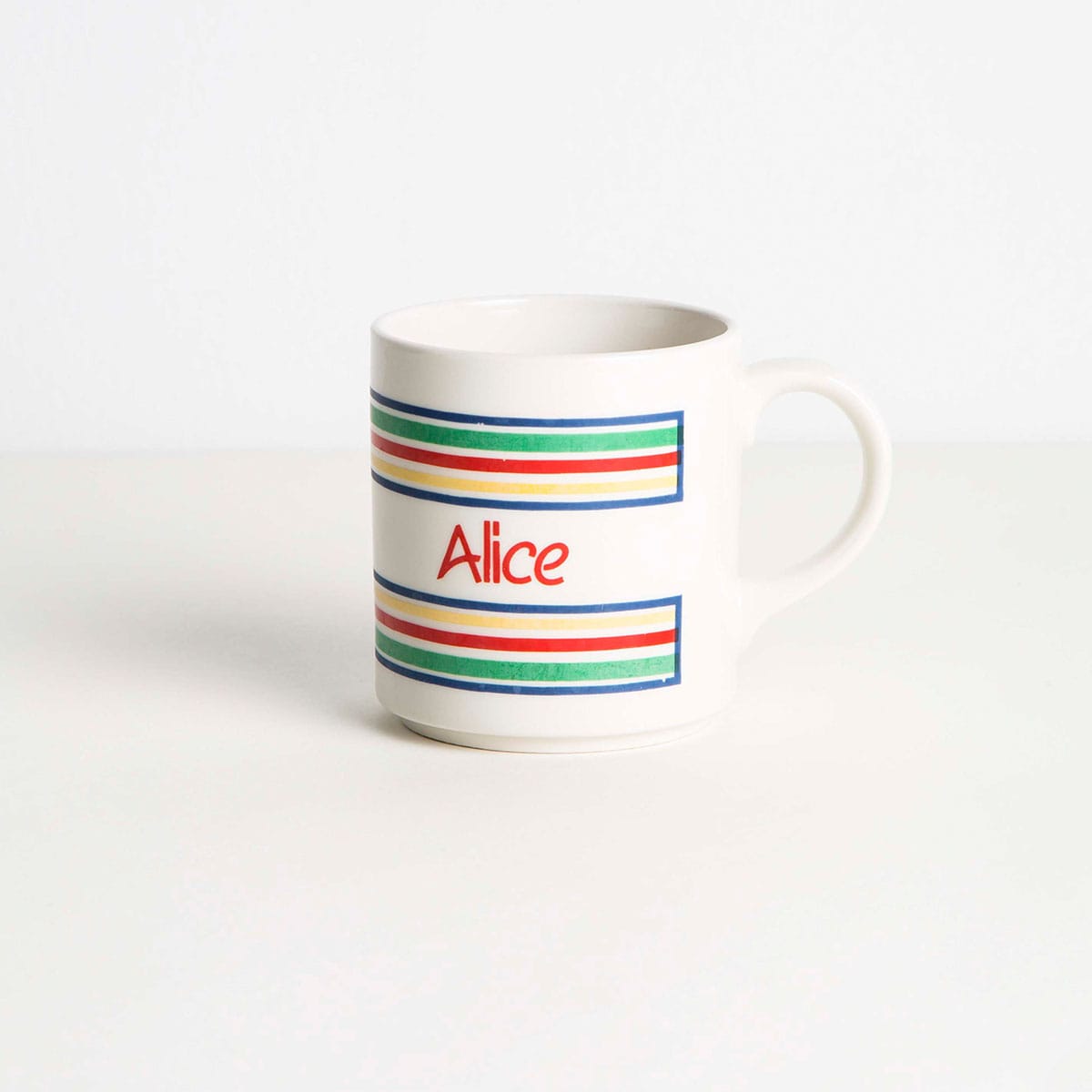 An empty coffee cup with the name Alice on it.