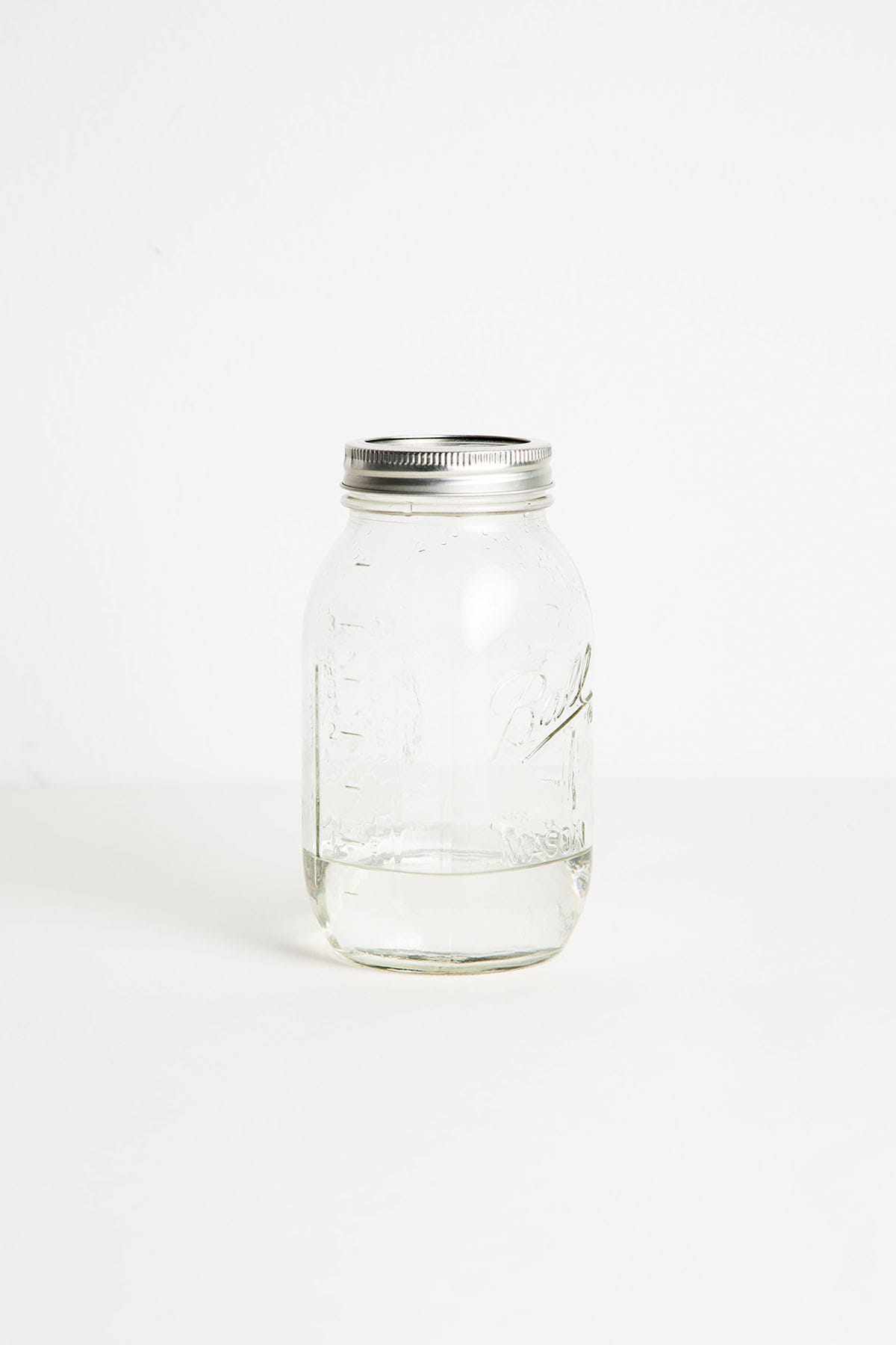 A nearly empty mason jar full of moonshine.