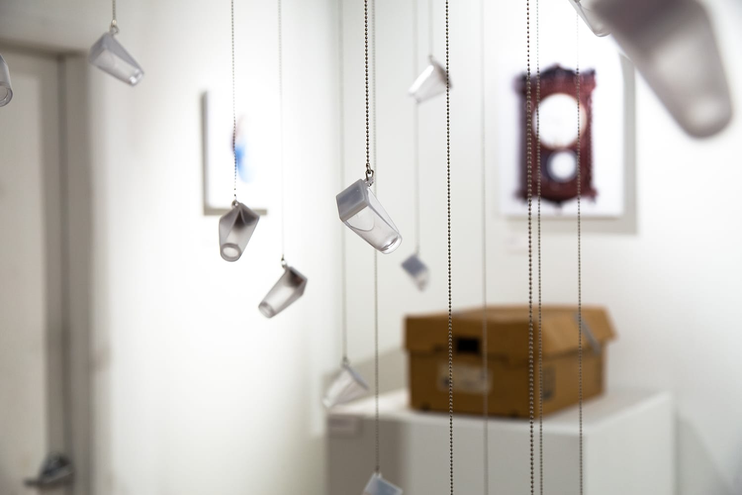 Glass bottles hanging from the ceiling on strings.
