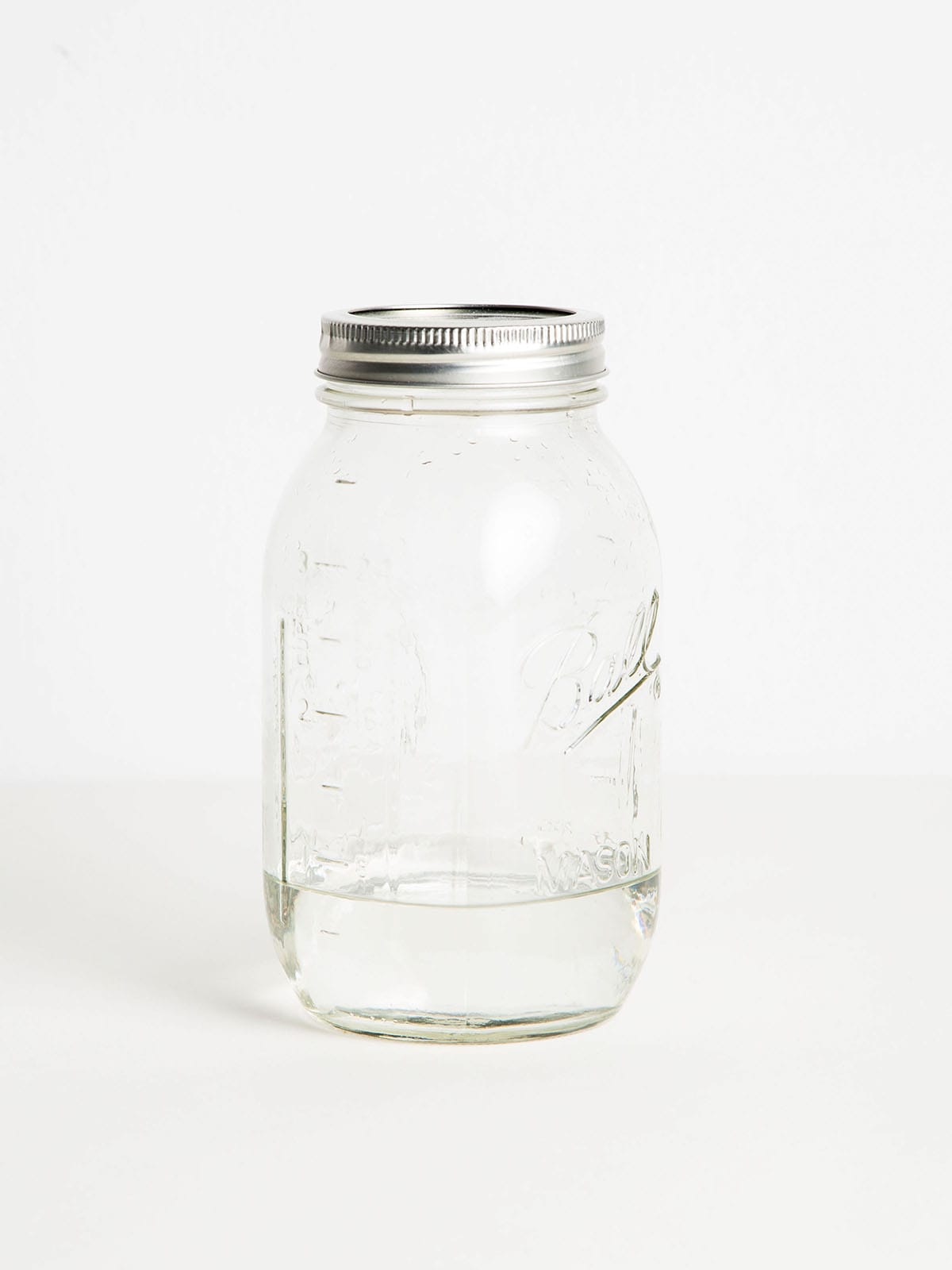 A nearly empty mason jar full of moonshine.