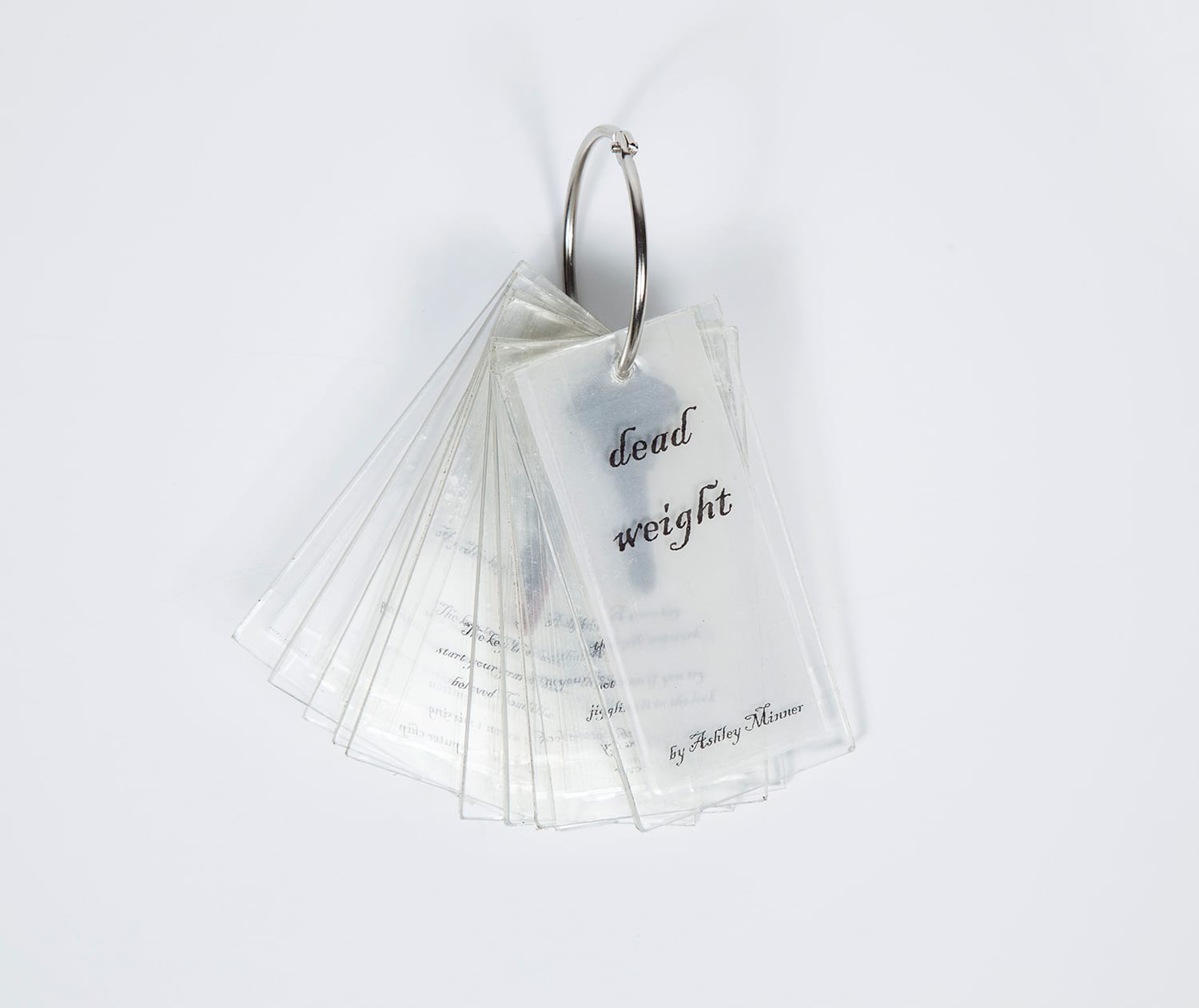 The cover of Dead Weight, a book made from plastic film strips on a keychain.